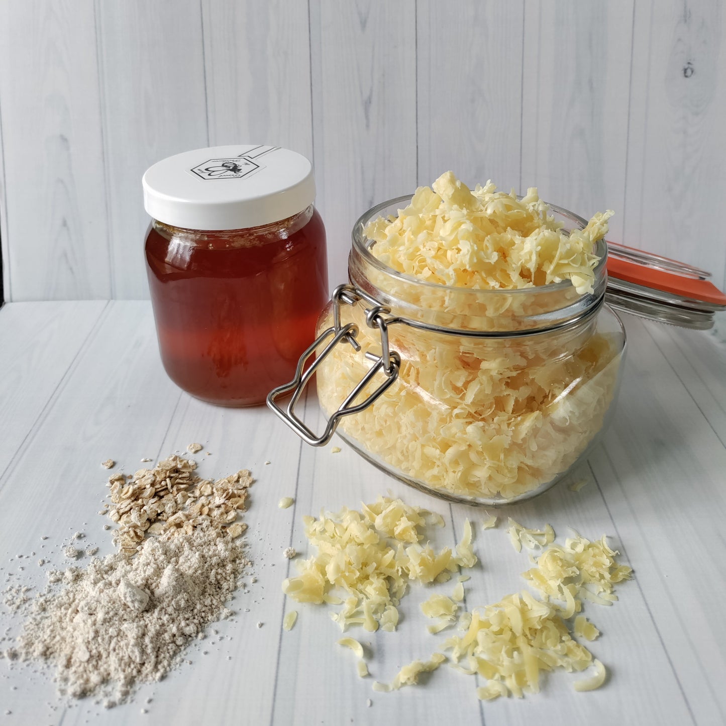 jar of honey and a jar of beeswax from my local beekeeper with some finely ground and normal sized oats